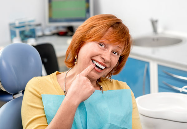 happy patient pointing to her implant